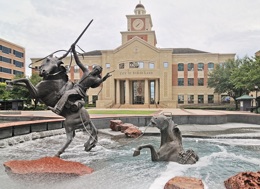 Sugar Land, TX - Statue of a Man Riding a Horse Rescuing Another Horse From the Water Inside a Water Fountain in Front of Sugar Land City Hall
